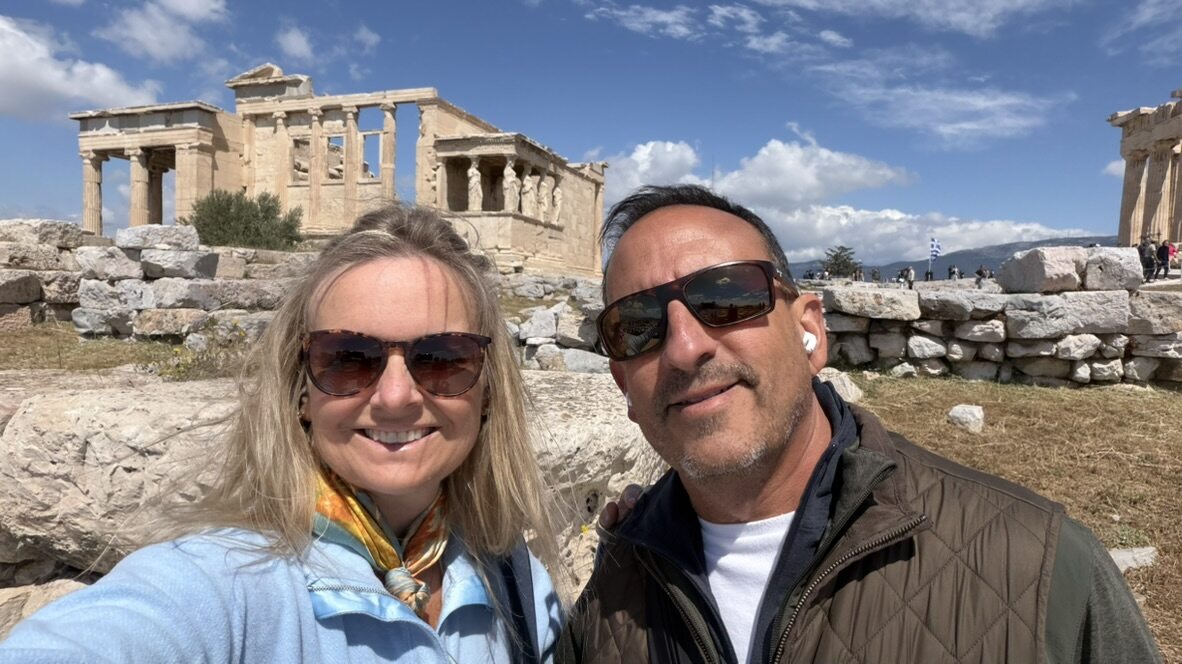 She-Stache and He-Stache smiling in front of the Erechtheion on the Acropolis