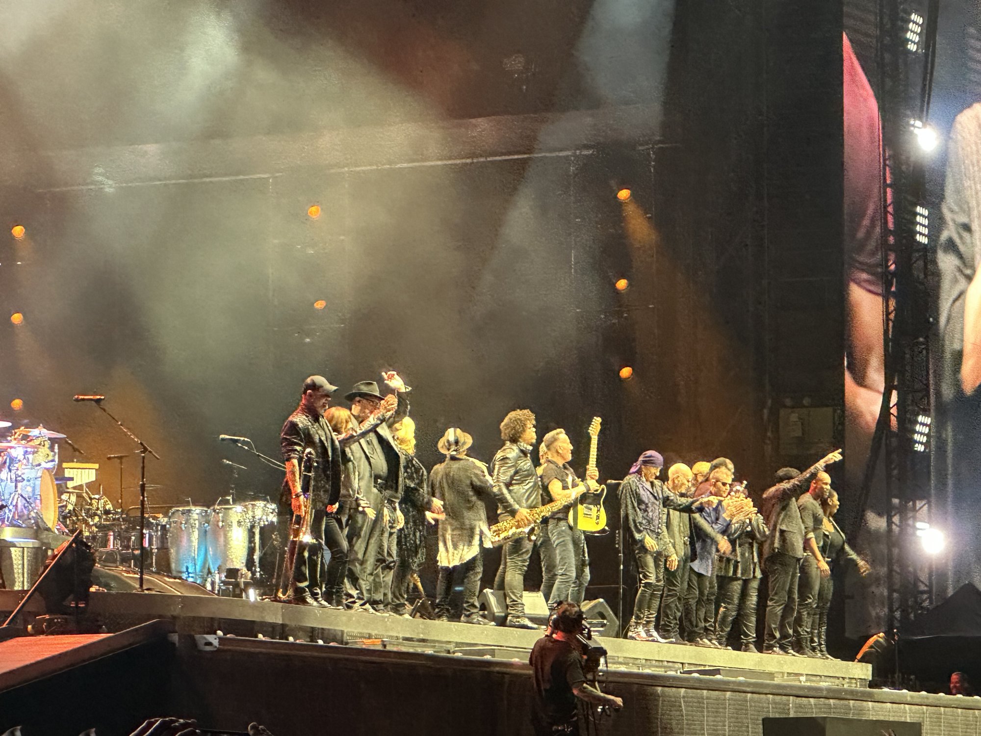 Band members lined up across a smoky, spot-lit stage