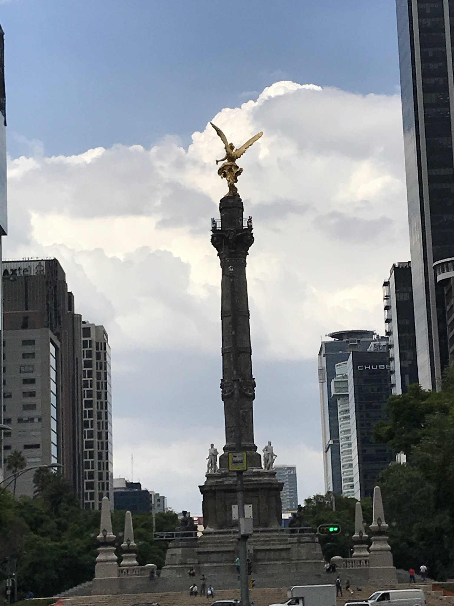 The gold Angel of Independence statue on its tall column above Paseo de la Reforma, glass towers on either side