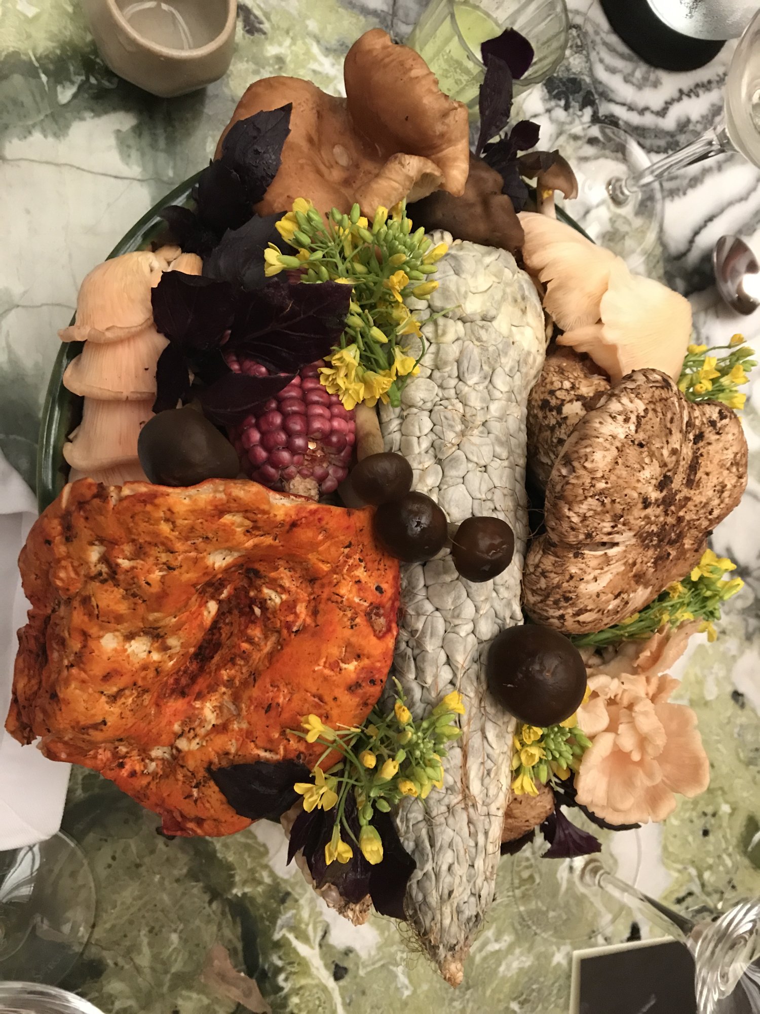 A platter of crispy fried pieces garnished with herbs and flowers