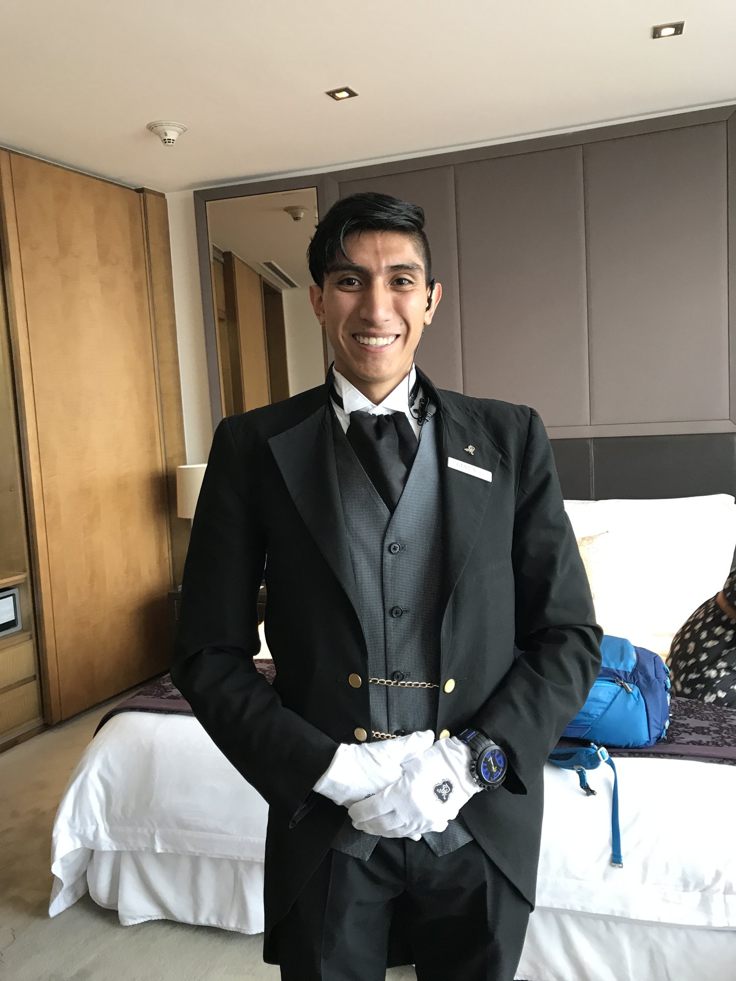 A butler in a tailcoat and white gloves standing in a hotel room at the St. Regis Mexico City