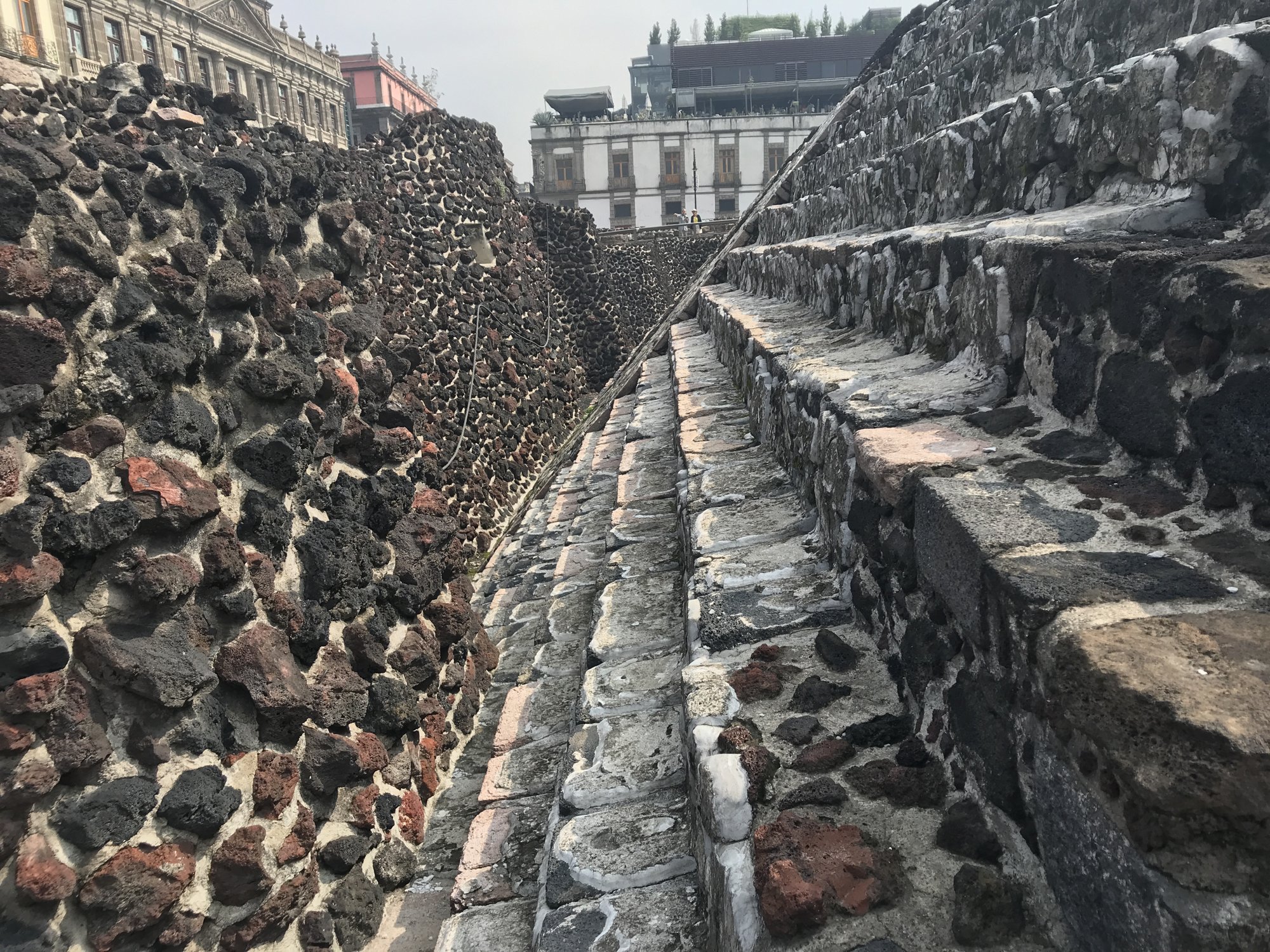 A narrow passage between rough stone temple walls at Templo Mayor