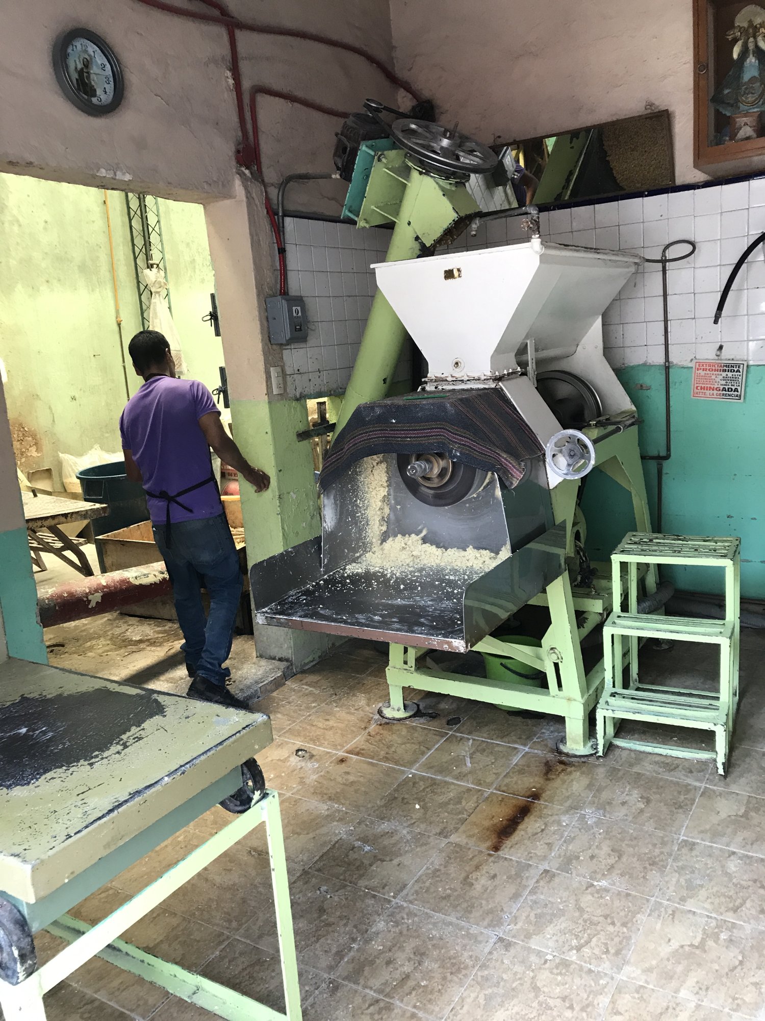 A tortilla machine pressing fresh tortillas at the market