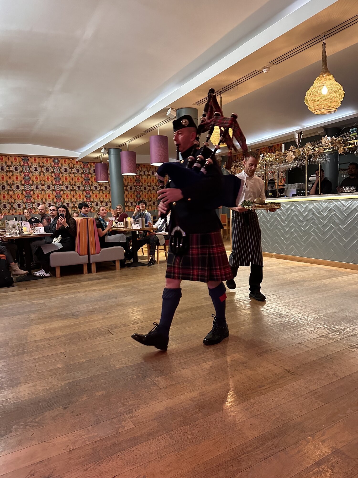 A piper leading the haggis into the Scottish Caf&eacute; & Restaurant for Burns Supper
