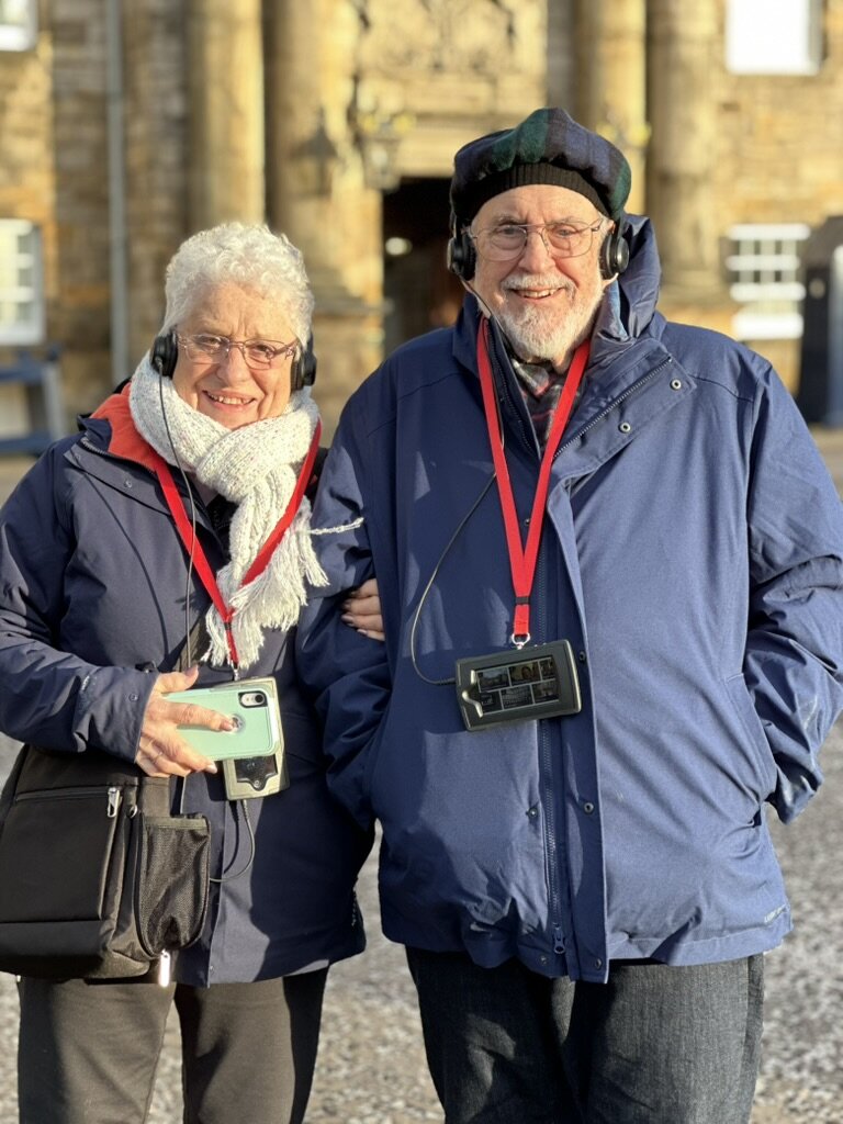 Mom and Dad wearing audio guide headsets outside Edinburgh Castle