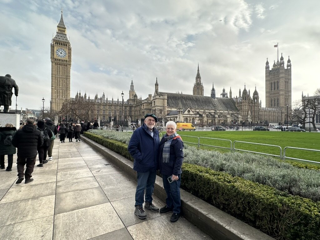 Mom and Dad on a Parliament Square pavement with Big Ben and the Houses of Parliament behind them