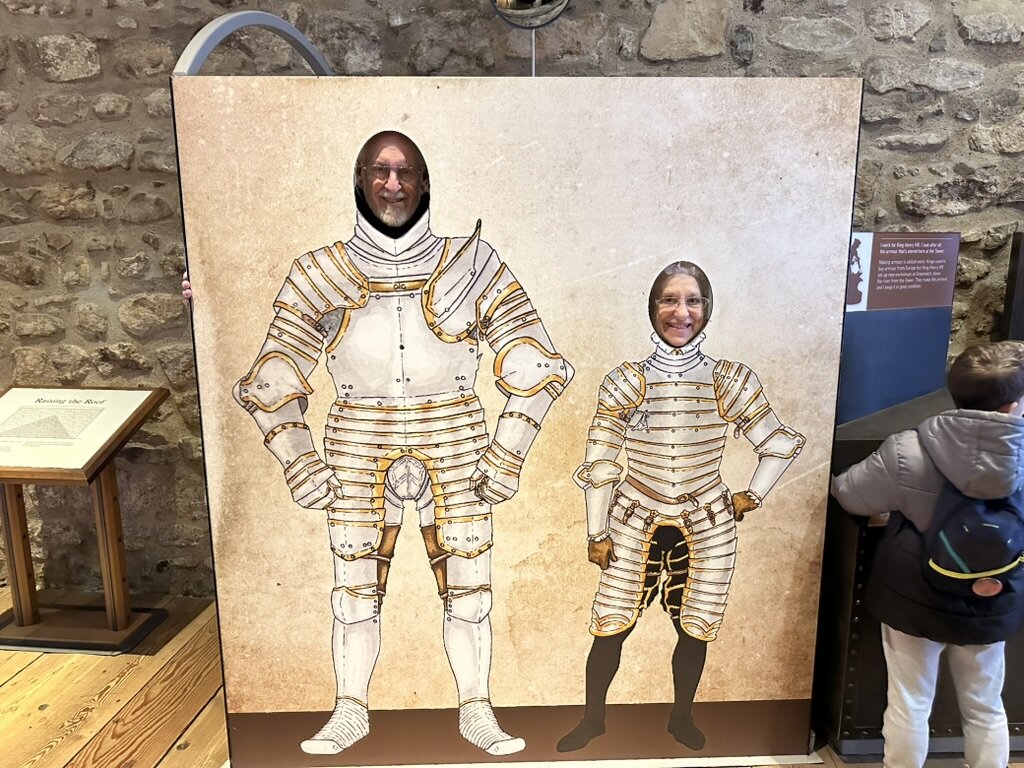 Mom and Dad with their faces in a Tudor armor photo cutout at the Tower of London