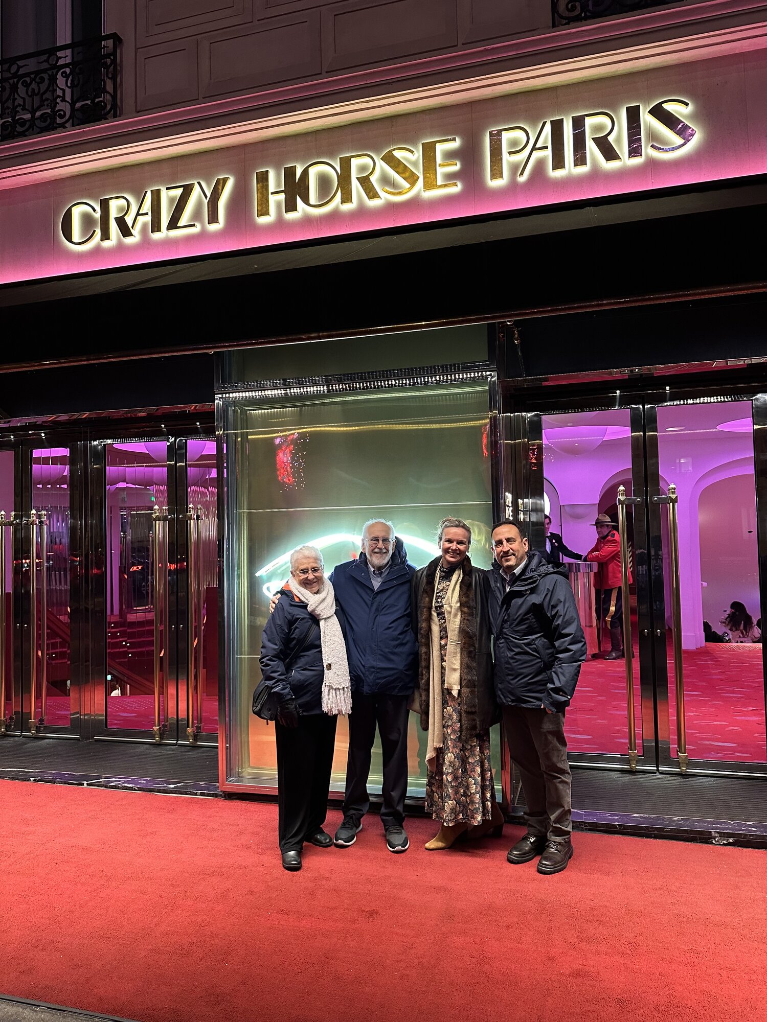 The family outside Crazy Horse Paris under the neon sign