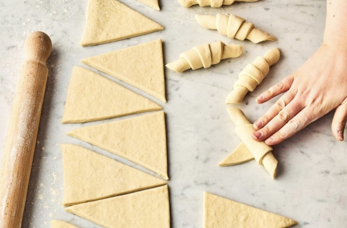 Hands shaping croissant dough at Maison Fleuret