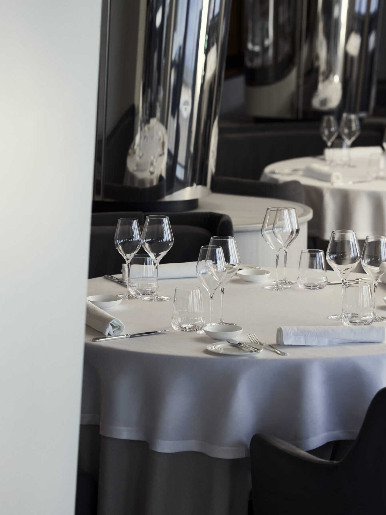 Explora media kit photo of an Anthology table set with white linens and stemware