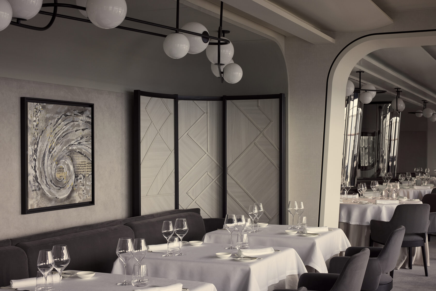 Explora media kit photo of the Anthology dining room, white tablecloths and stemware under globe lights