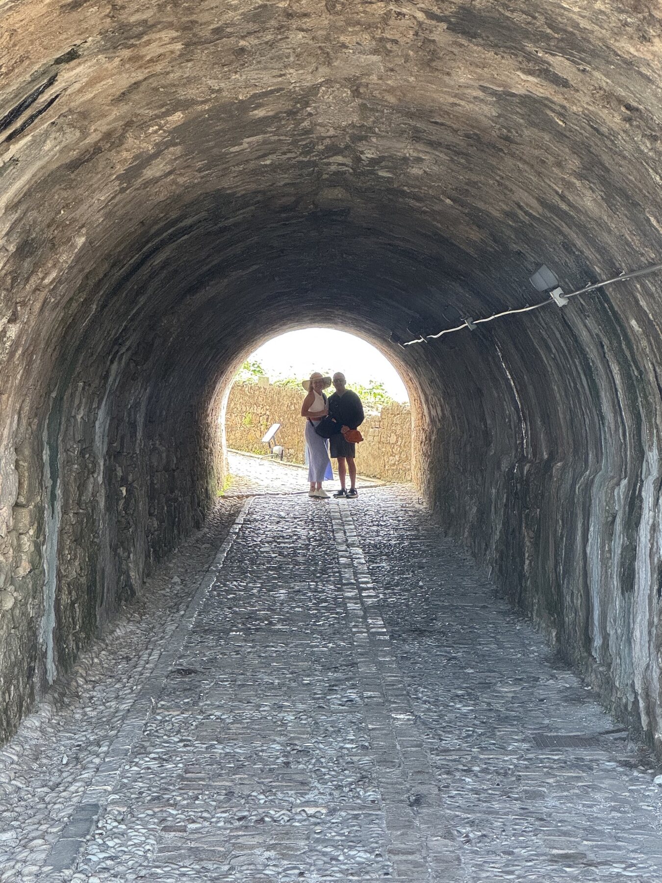 The Staches silhouetted at the end of a long cobbled stone tunnel inside the fortress in Corfu