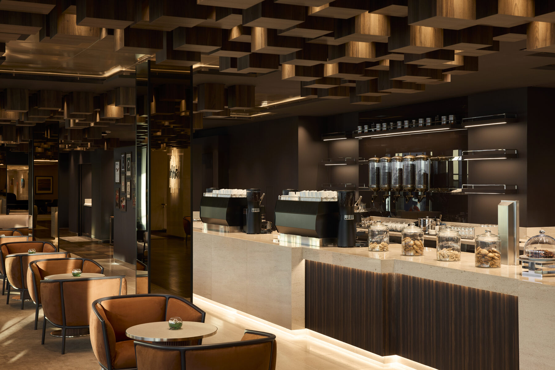 Explora media kit photo of Crema Caf&eacute;, espresso machines, coffee bean dispensers, and jars of cookies on a stone counter