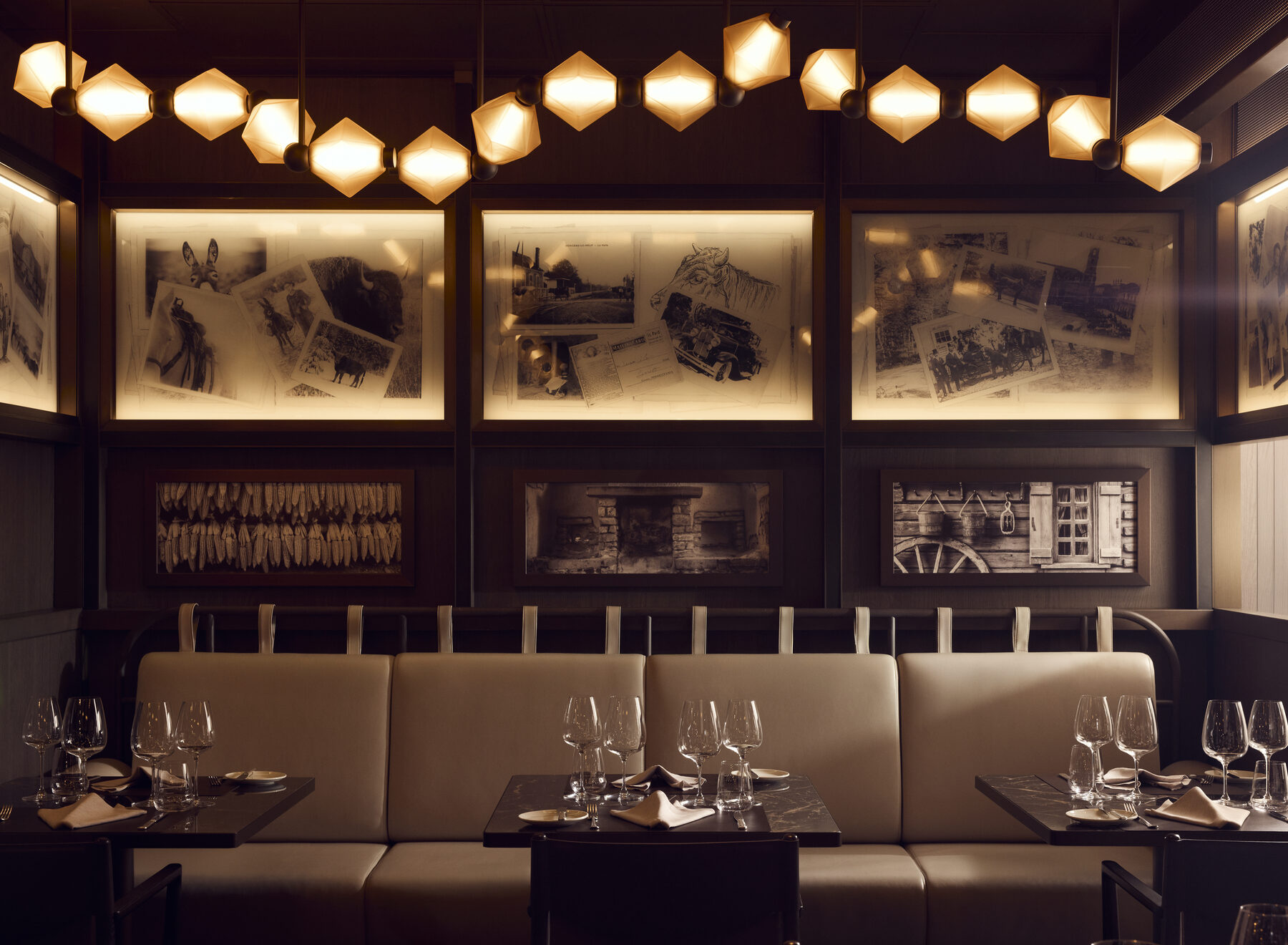 Explora media kit photo of Marble & Co. Grill, leather banquettes and set tables under hexagonal pendant lights