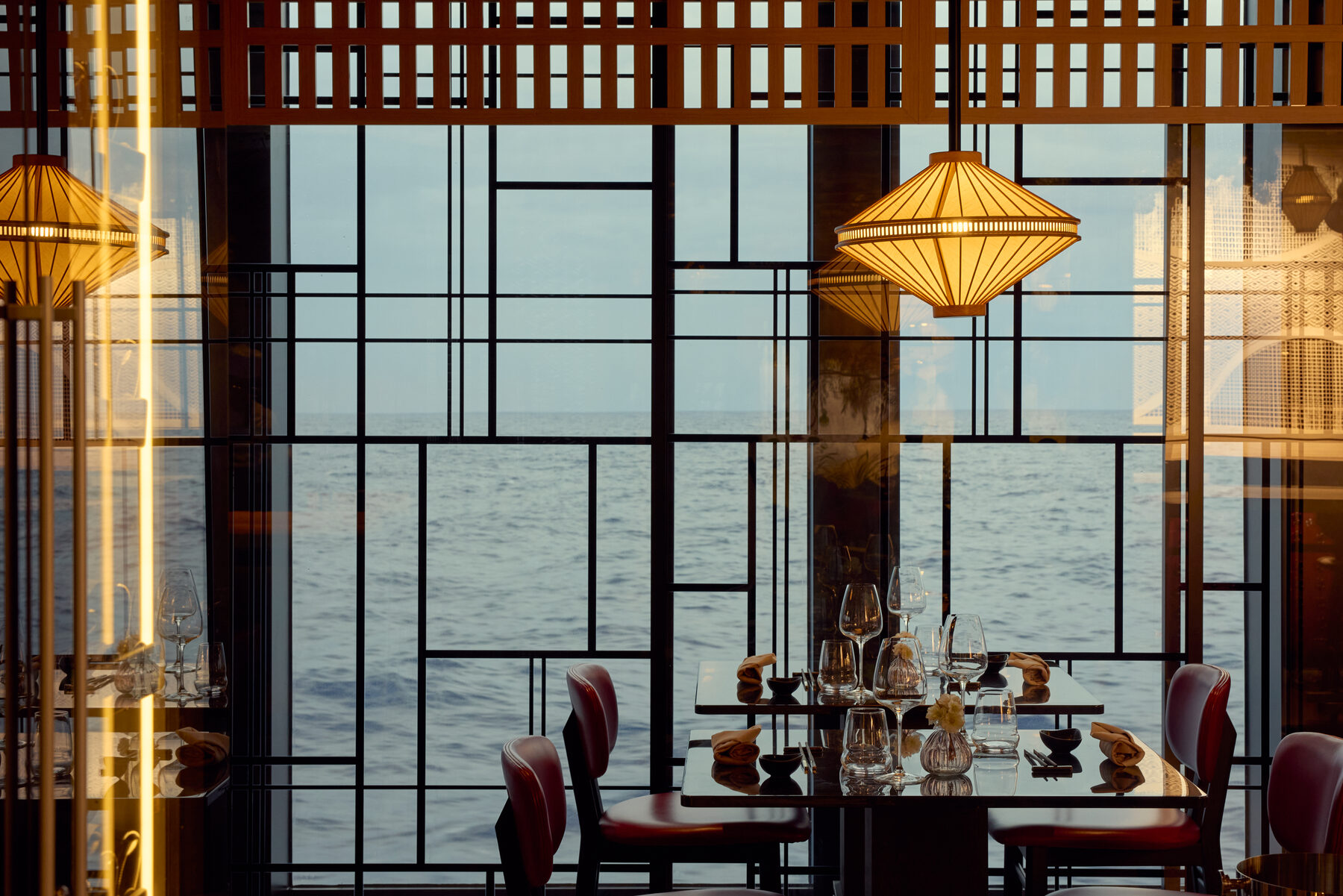 Explora media kit photo of Sakura restaurant, tables set beside floor-to-ceiling windows over the sea