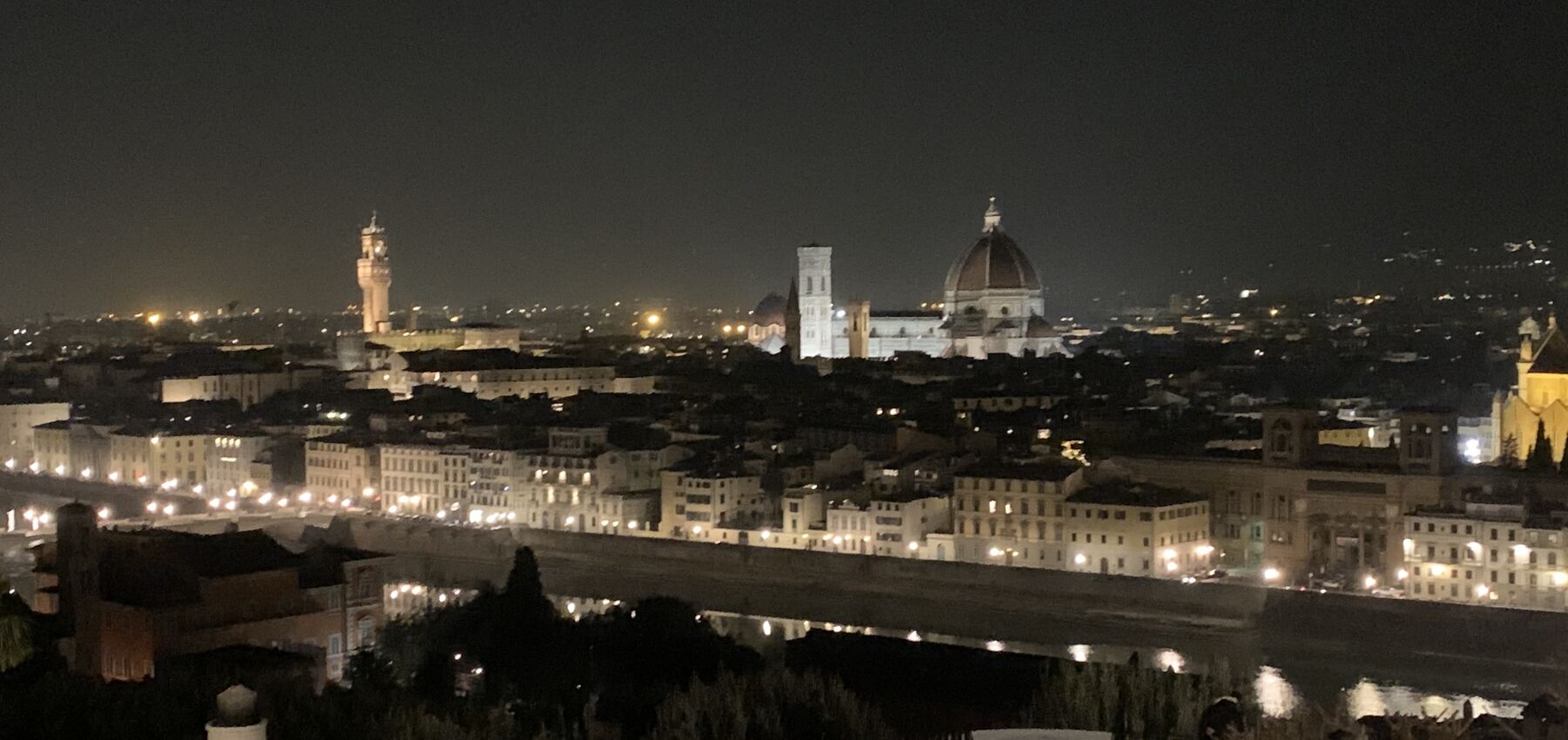 Florence skyline by night, the Duomo lit up over the Arno