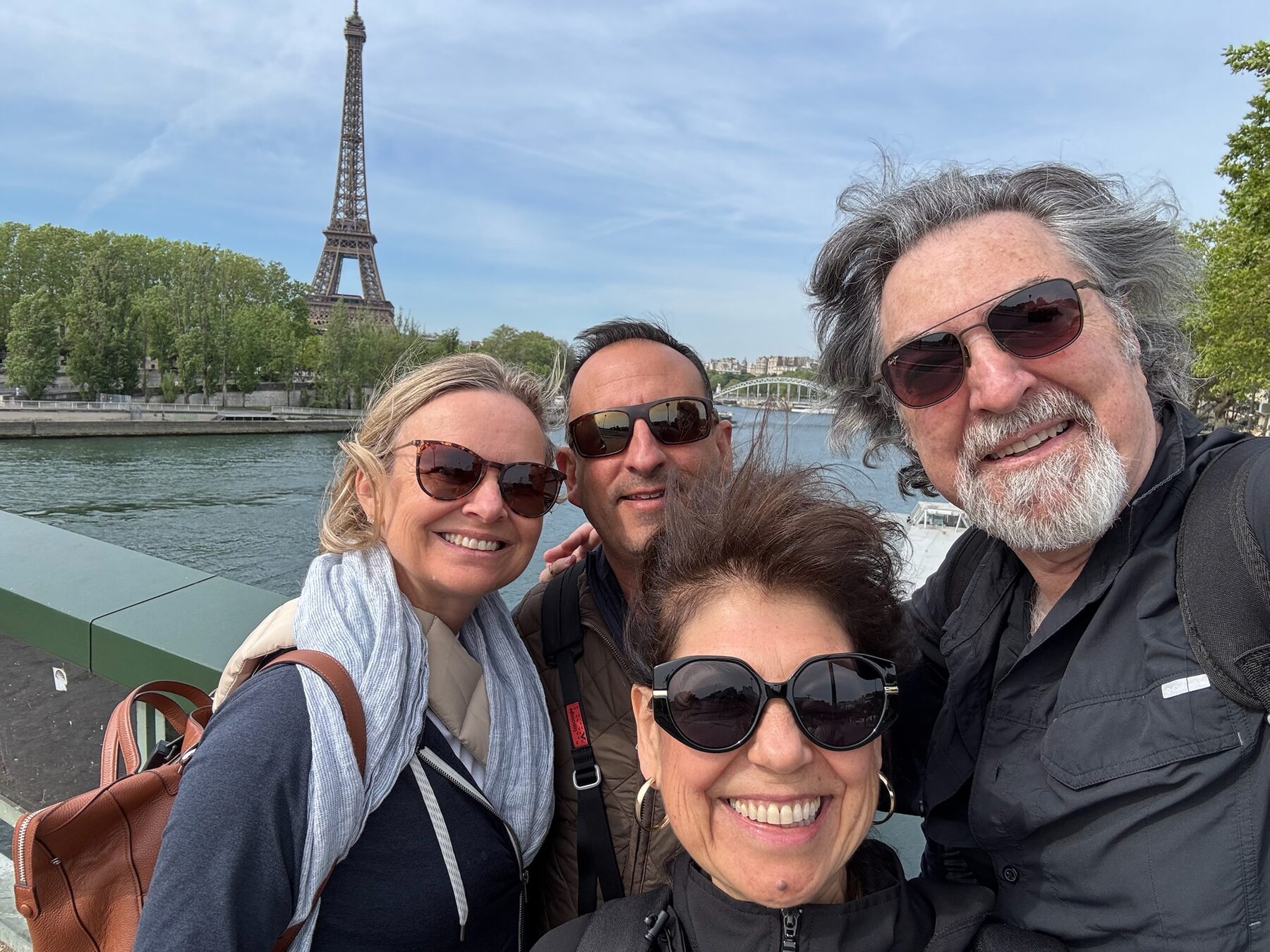She-Stache, He-Stache and two friends taking a selfie on the Seine embankment with the Eiffel Tower behind them