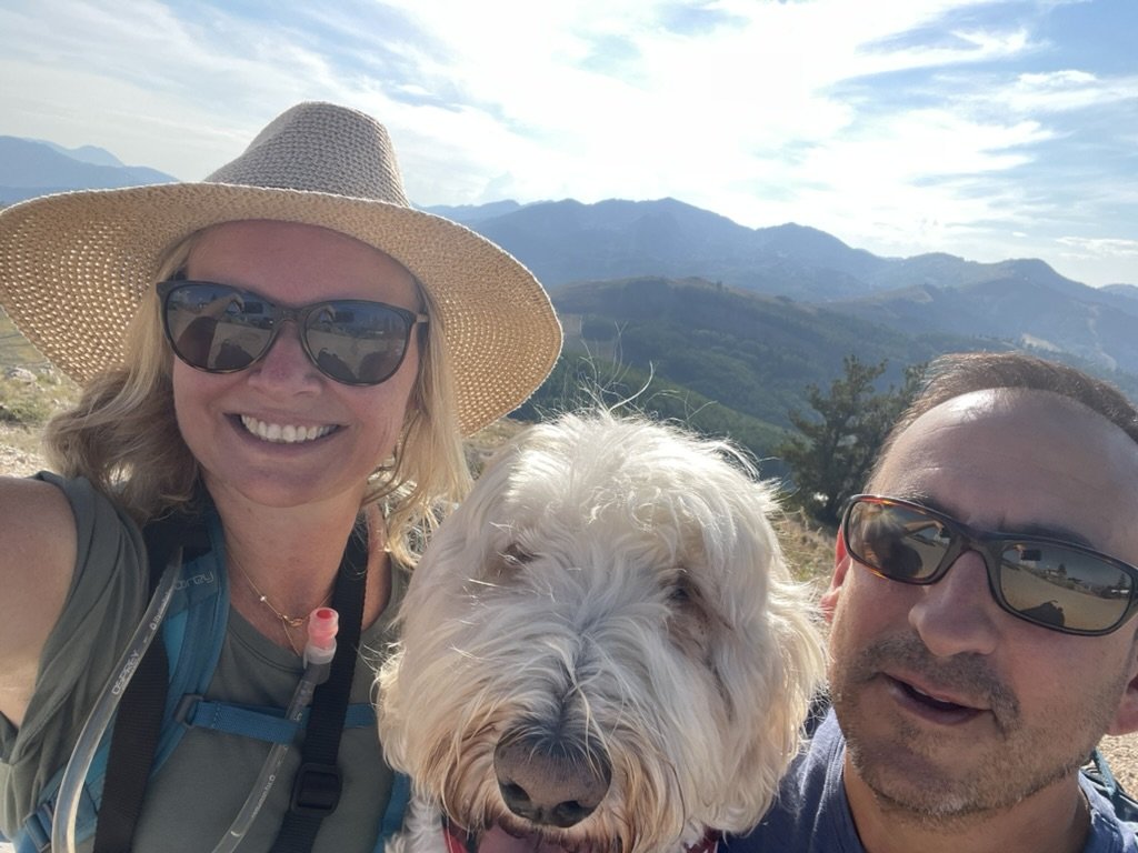 She-Stache in a straw hat, Pup-Stache and He-Stache squeezed into a selfie on a ridge above Deer Valley