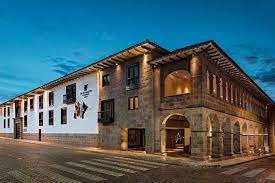 A stone hotel with arched doorways, lit at dusk