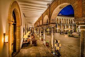 A lit stone arcade surrounding a courtyard at night
