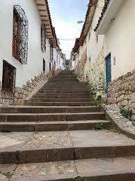 A steep stone staircase between whitewashed walls on a Cusco street