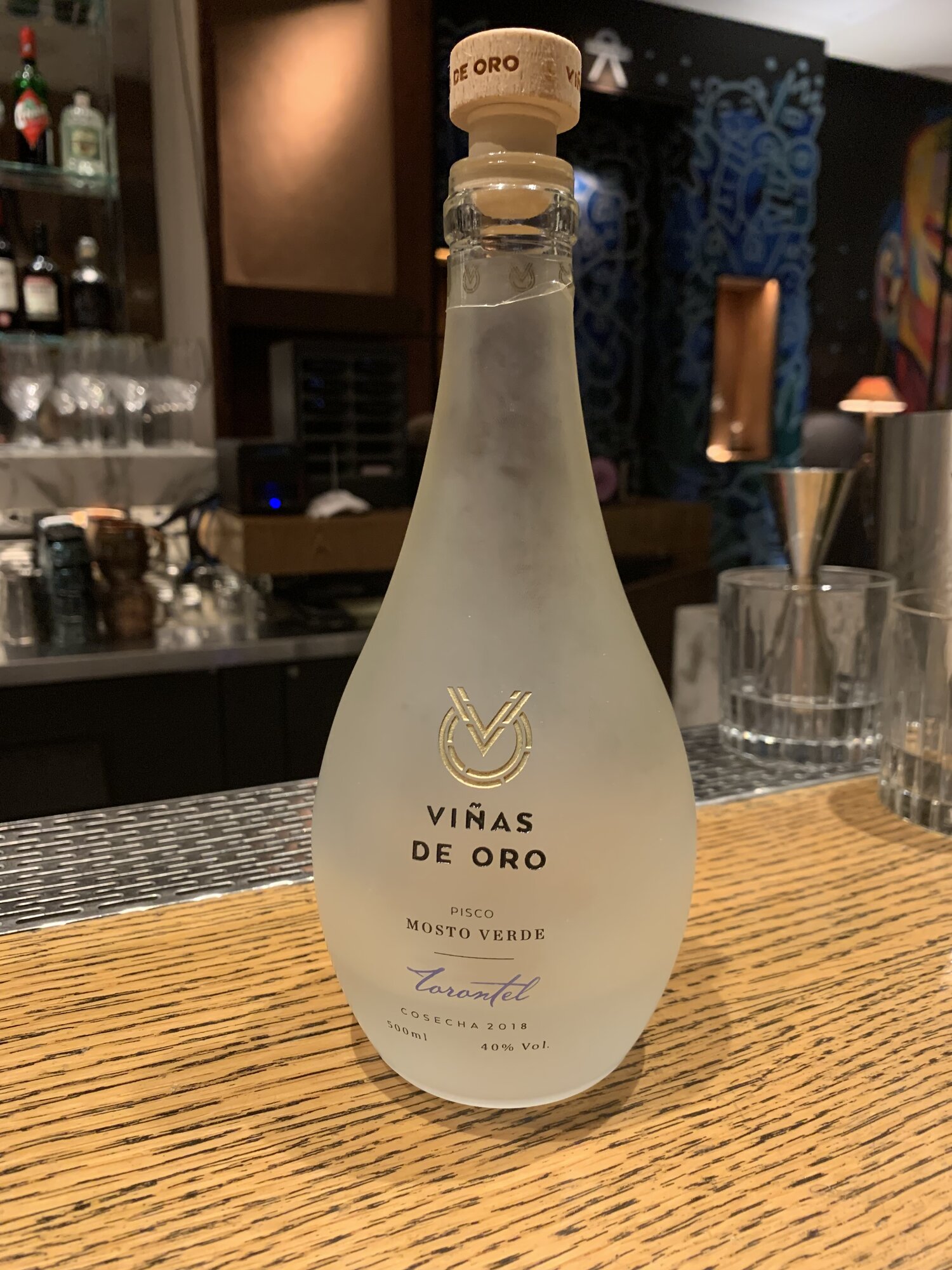 A frosted bottle of Vi&ntilde;as de Oro pisco on a bar