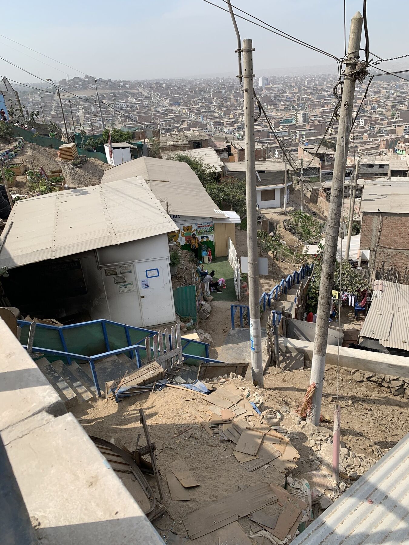 A small community school on a steep, unpaved hillside in a Lima pueblo joven