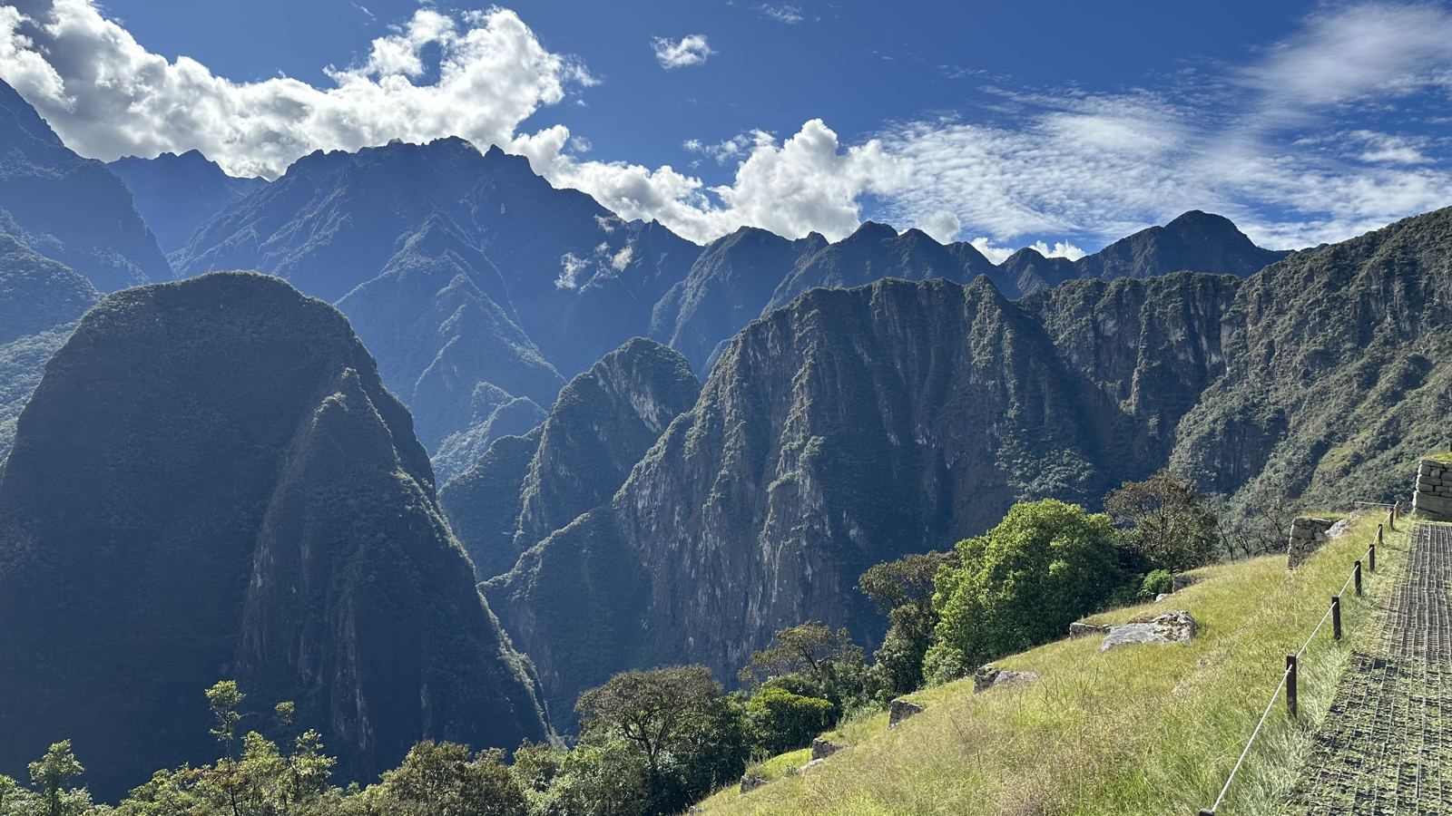 Green and grey Andean peaks with a stone terrace edge in the foreground