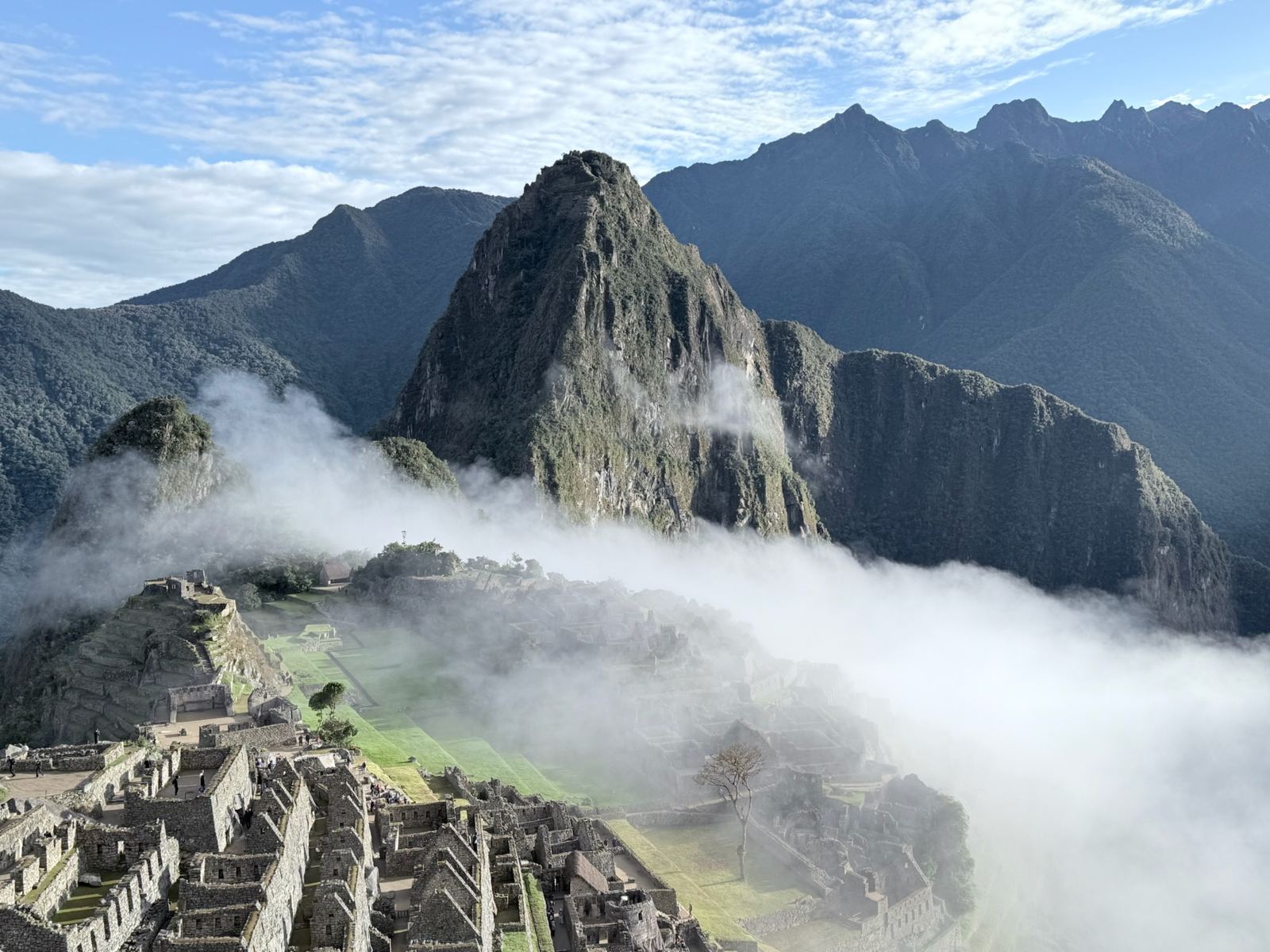 Machu Picchu and Huayna Picchu rising above clouds that fill the valley
