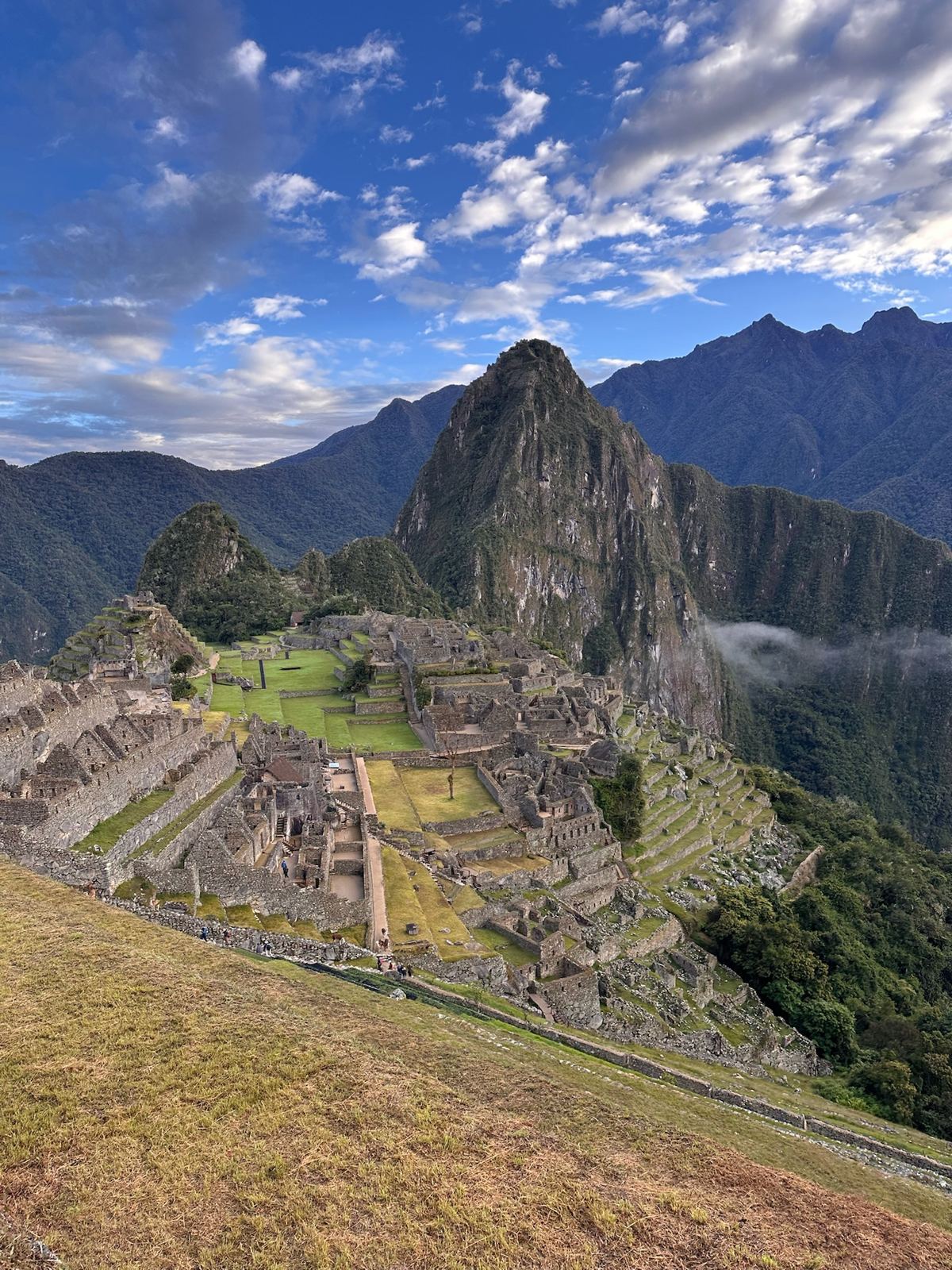 The ruins and Huayna Picchu under scattered clouds