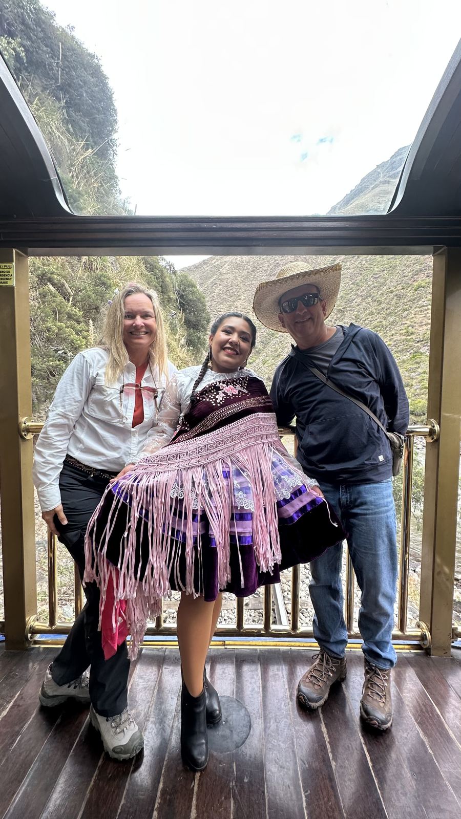 She-Stache and He-Stache posing with a woman in traditional dress on the open-air observation platform of the train