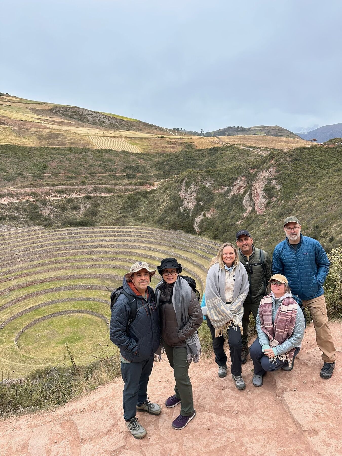 The six travelers standing above the circular terraces of Moray