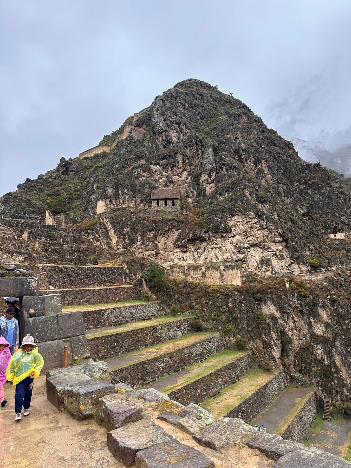 A small stone storehouse perched on the steep hillside above the terraces at Ollantaytambo