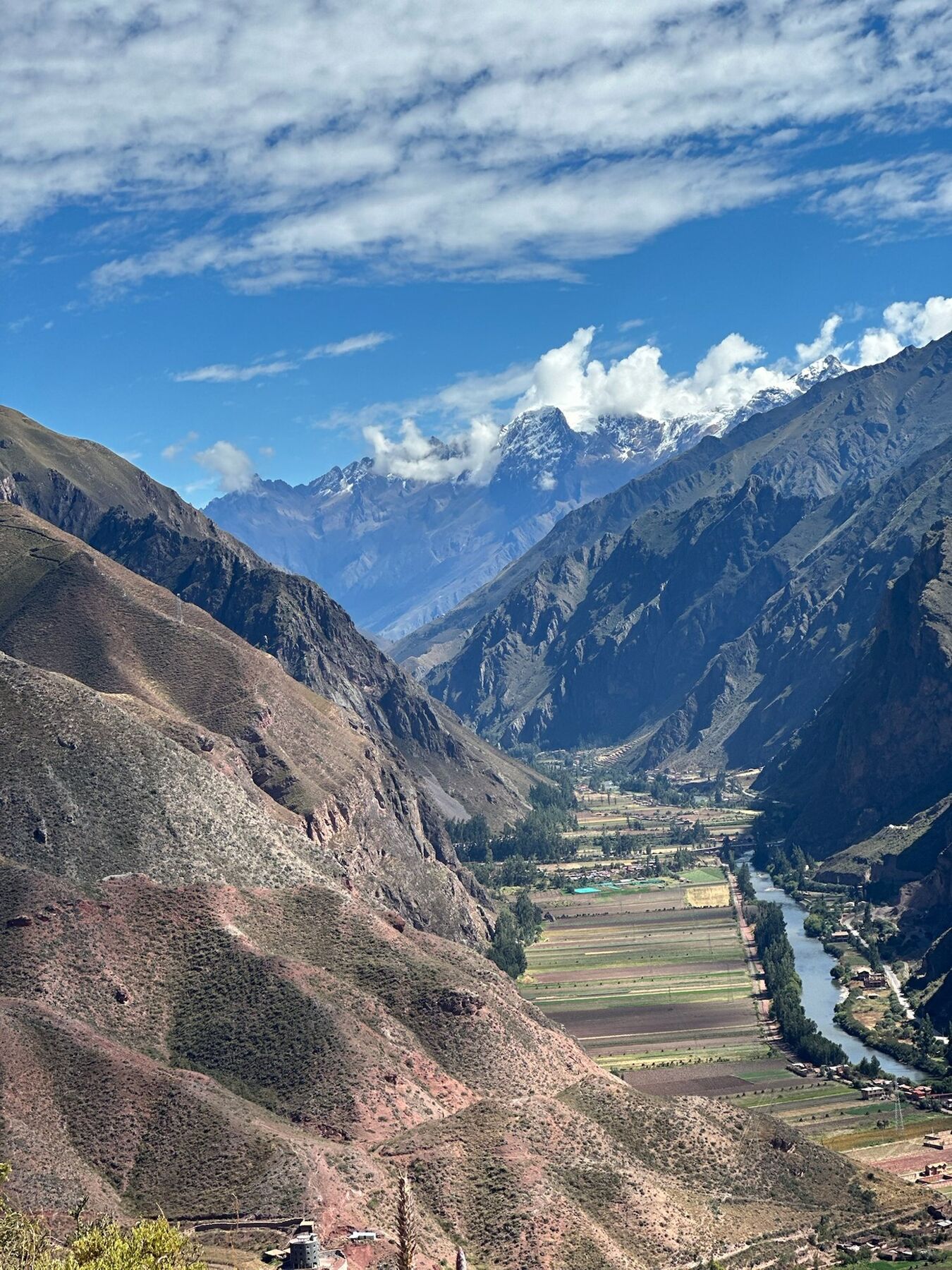 The Urubamba River winding through a patchwork of farm fields below snow-capped peaks in the Sacred Valley