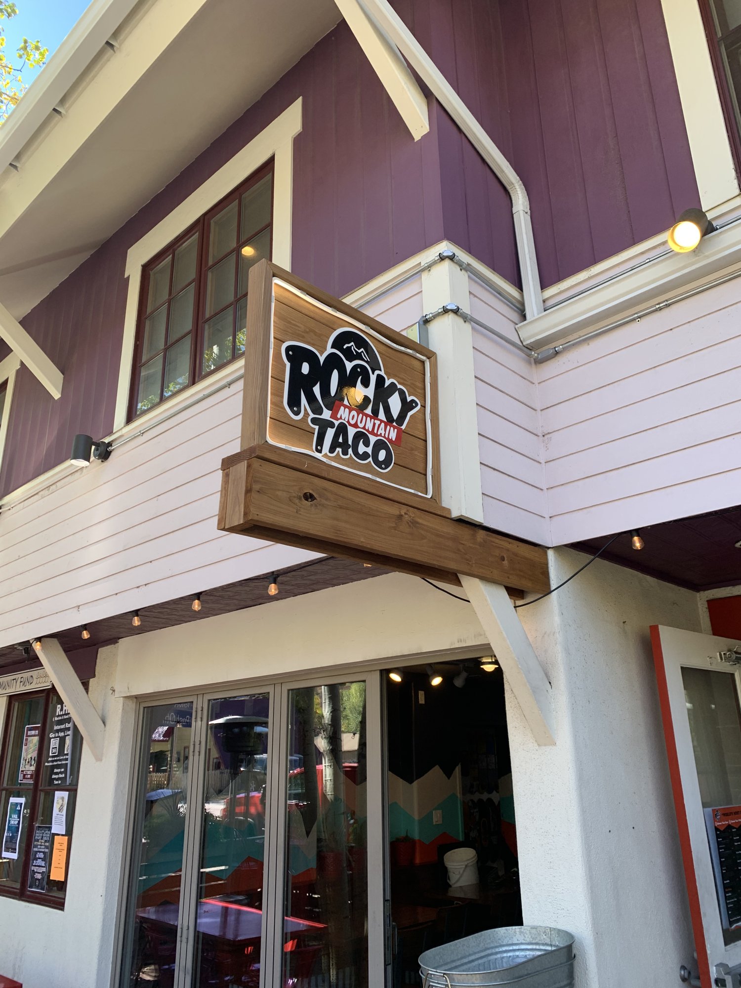 The front of a small pink-and-white building with a Rocky Mountain Taco sign above the door in Minturn