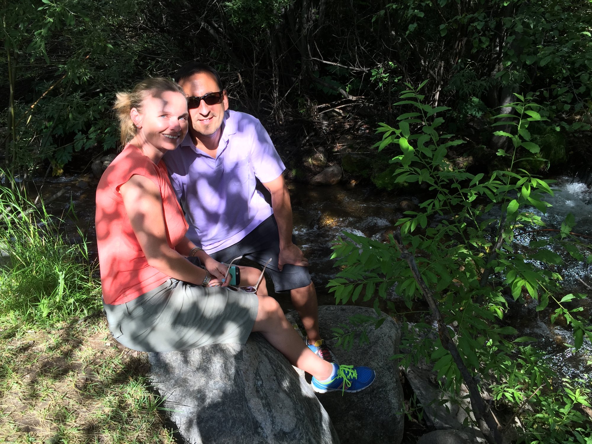 She-Stache and He-Stache sitting together on a rock in a shady forest on the Beaver Lake Trail