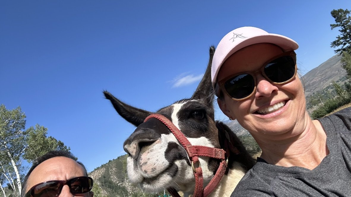 She-Stache and He-Stache taking a selfie with a llama&rsquo;s face filling the middle of the frame