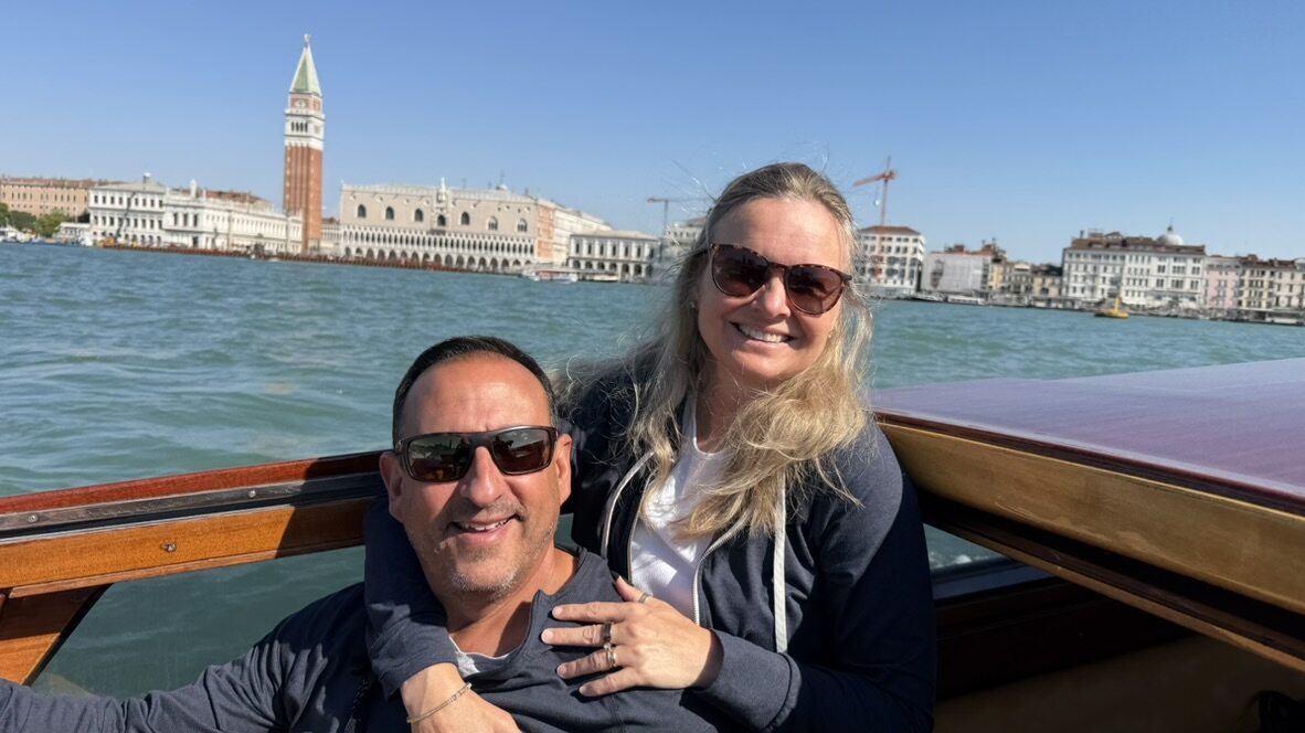 She-Stache and He-Stache in the back of a water taxi passing San Marco